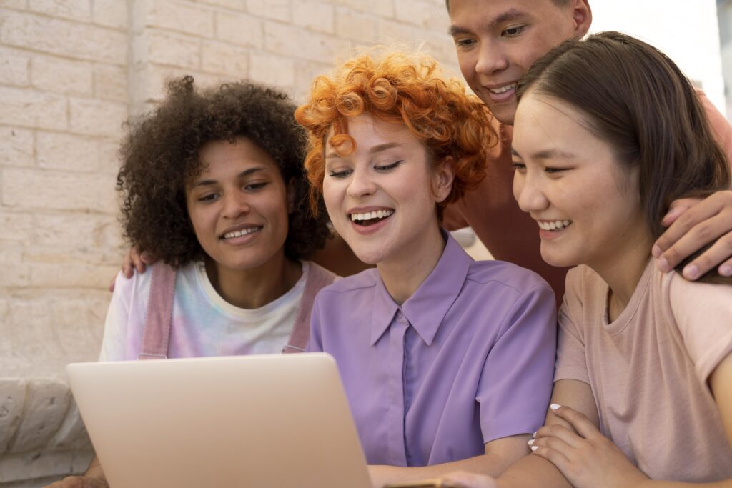 Imagem de pessoas felizes em frente a um PC - imagem escolhida para ilustrar o artigo sobre educação corporativa impulsionar a retenção de talentos